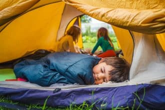 Enfant heureux dormant paisiblement dans un sac de couchage coloré
